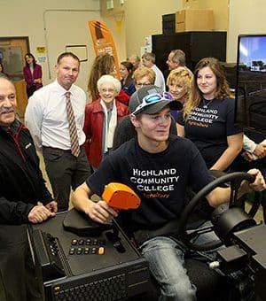 Photo of Jay Kempel watching Lucas Boomgarden navigate the agriculture simulator