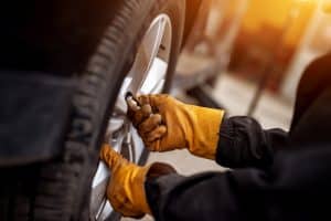 Close up on an auto tech changing a tire.