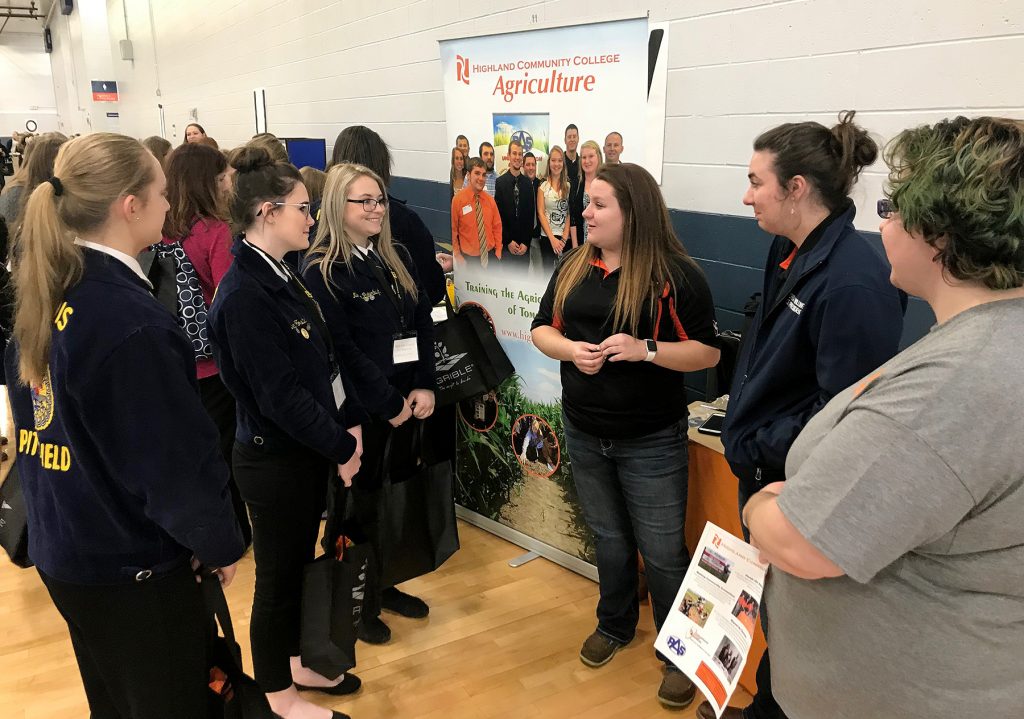 Students at a career fair speaking to a representative of Highland Community College's Agriculture degree program