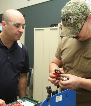 A cnc student works with an instructor