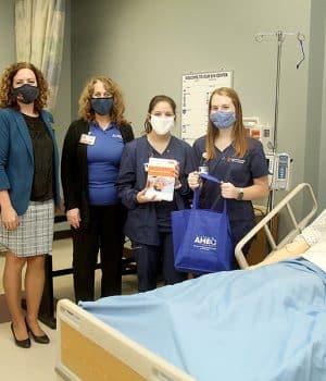 Nursing students and students pose with the SIM man