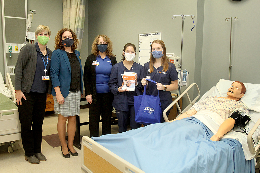 Nursing students and students pose with the SIM man