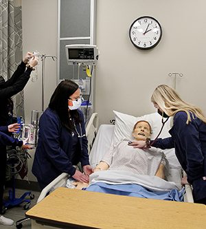 nursing students working on a SIM man