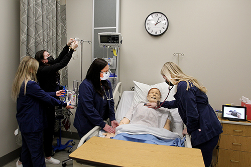 nursing students working on a SIM man