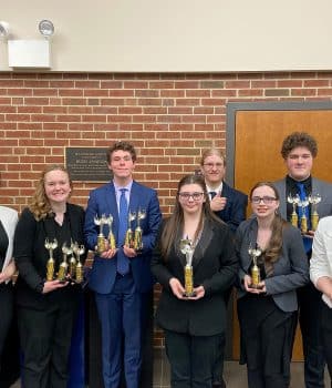 Speech team members pose with trophies