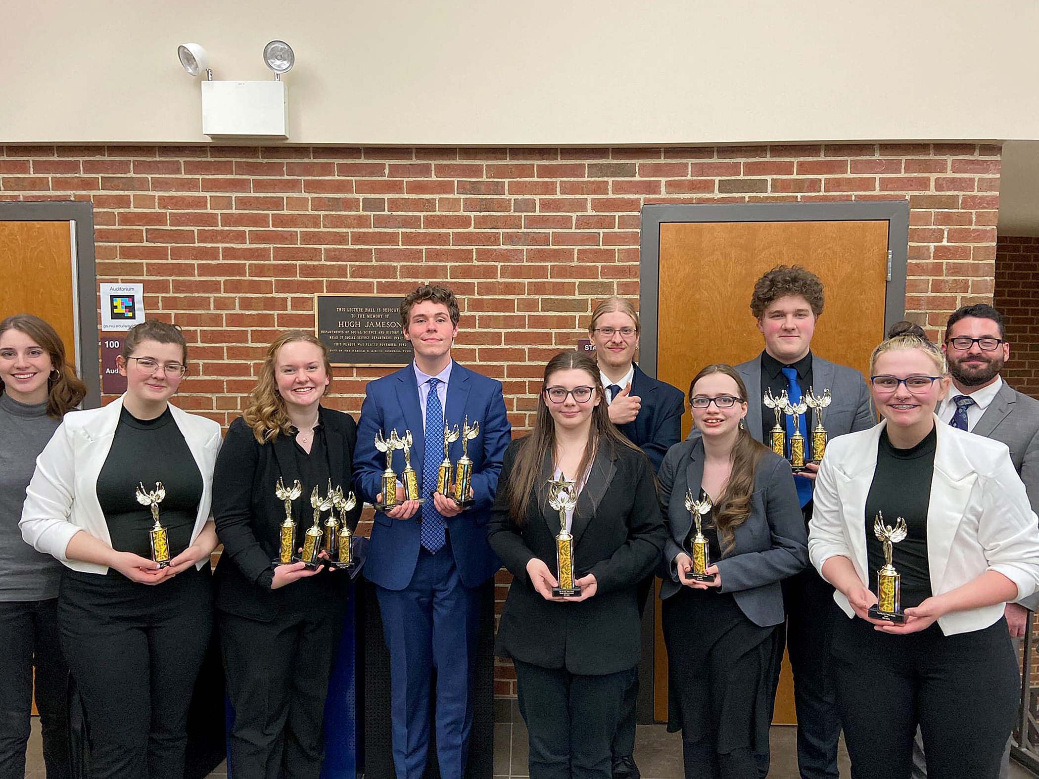 Speech team members pose with trophies