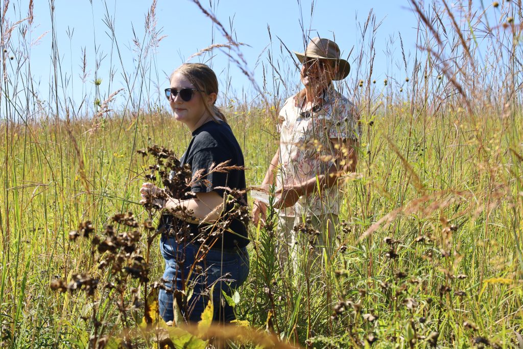 Highland student and faculty member in a prairie field