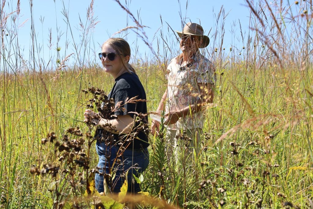 Highland student and faculty member in a prairie field