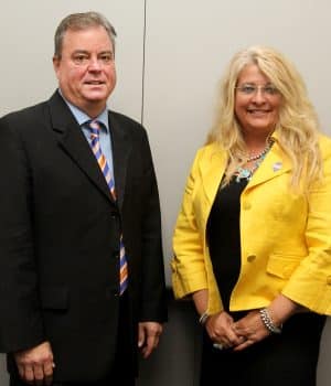 Shawn Boldt and Pennie Groezinger stand against a beige background