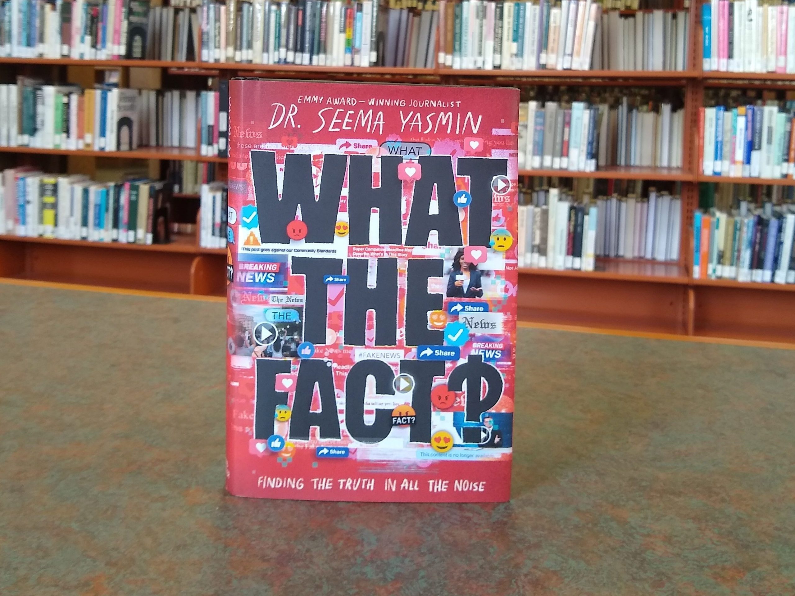 A copy of "What the Fact?!" by Dr. Seema Yasmin sits on a table in the library