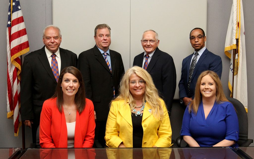 The board of trustees: four men and three women in business professional attire.