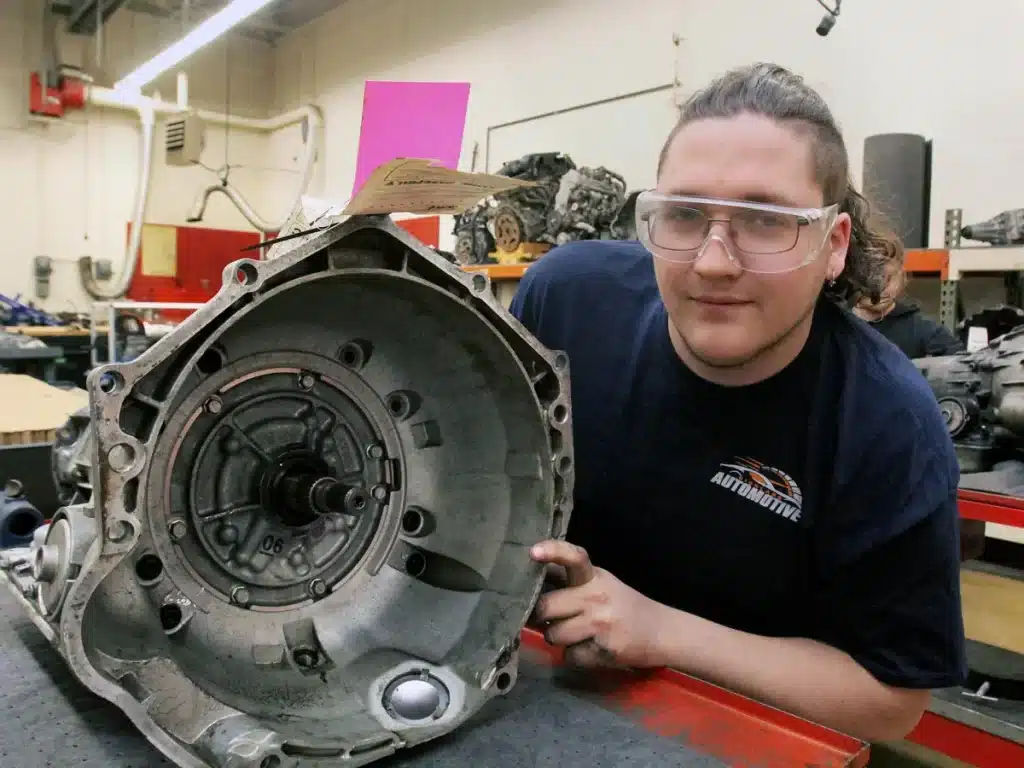 A student next to an engine