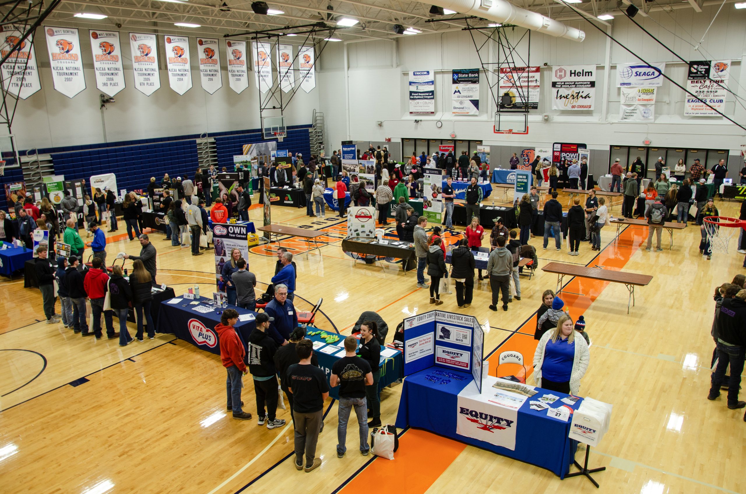 A group of students and industry empoyers gather in the Highland Sports Complex/YMCA gym.