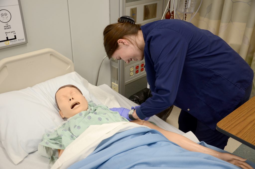 a student practicing medicine on a dummy patient