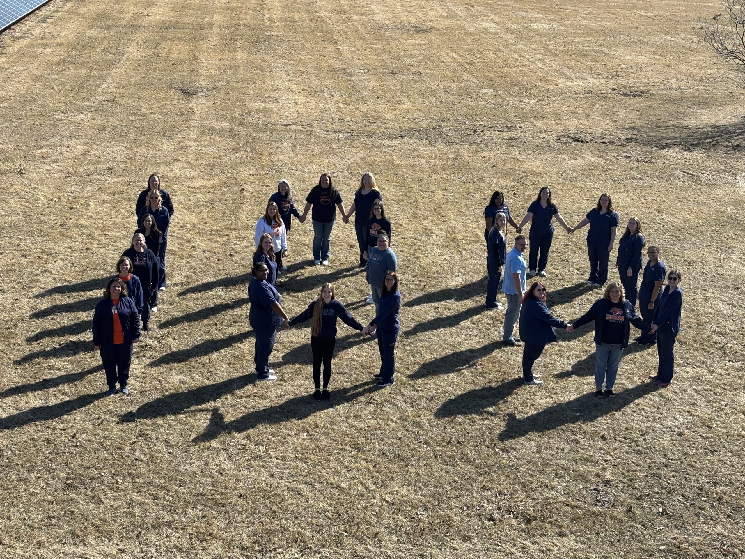 image of nursing students standing on lawn in the form of the number 100.