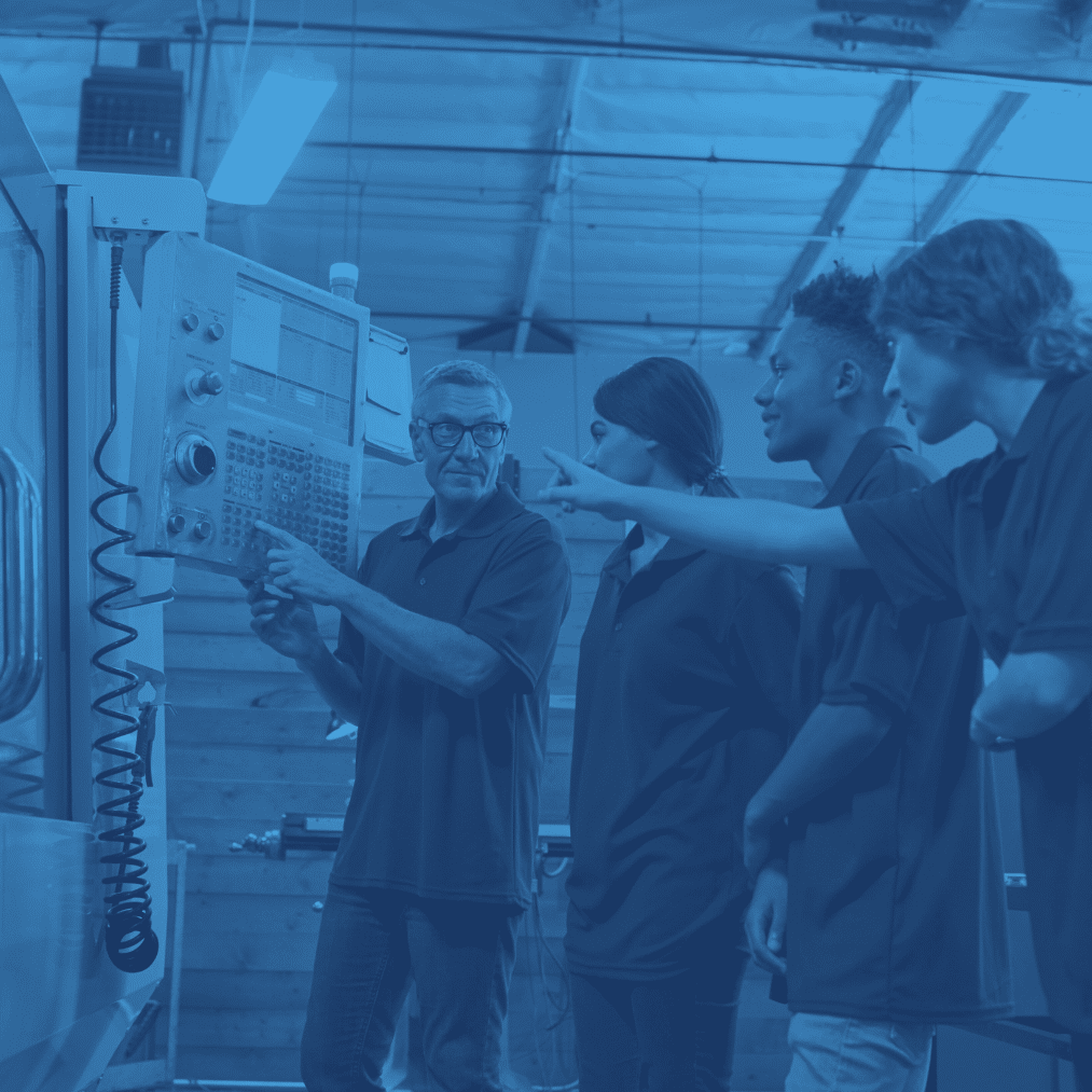 instructor teaching students in manufacturing plant