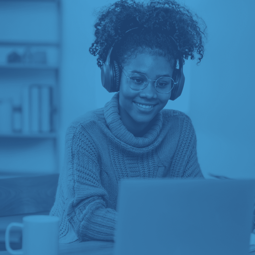 student in front of a computer screen smiling