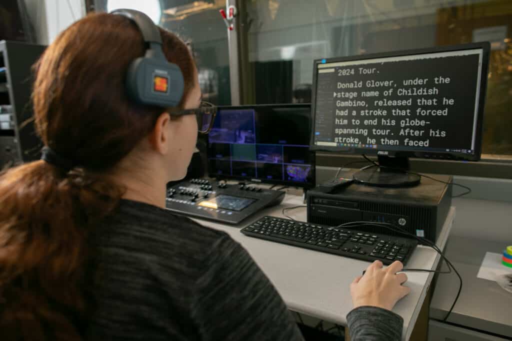 student in media room reading a computer screen with teleprompter words