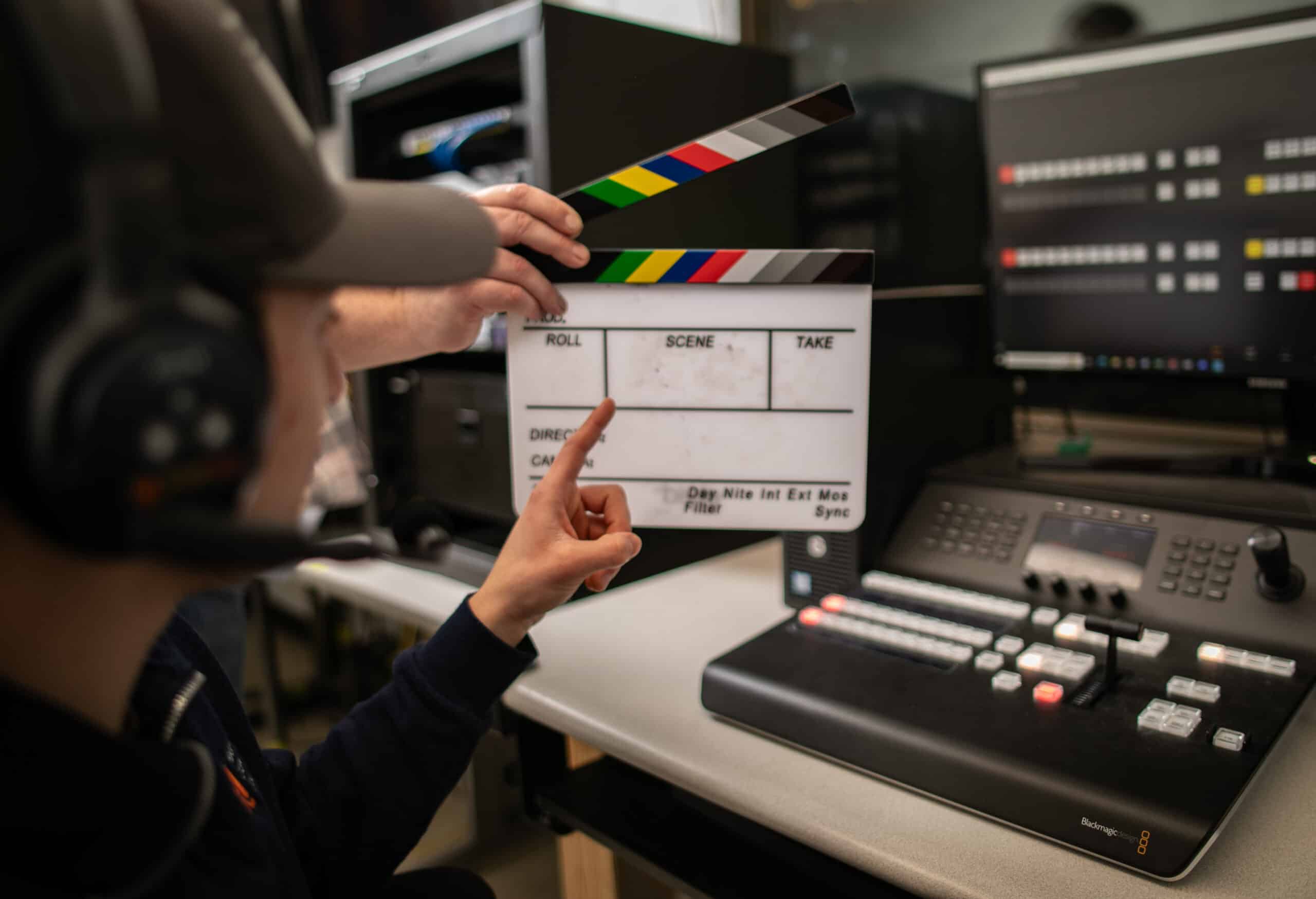 media clapper in open motion in front of a computer screen